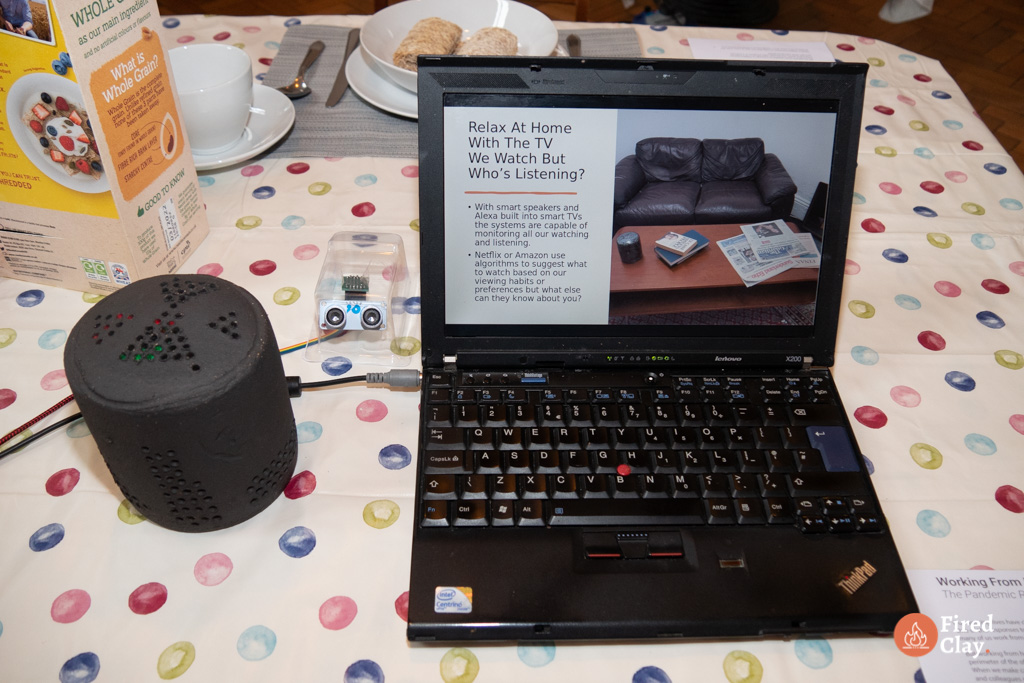 Image of a laptop showing powerpoint presentation with a black alexa in ceramic